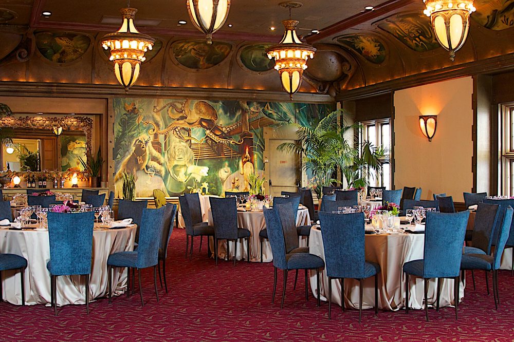 The Beluga Room set with round tables beneath a painted mural